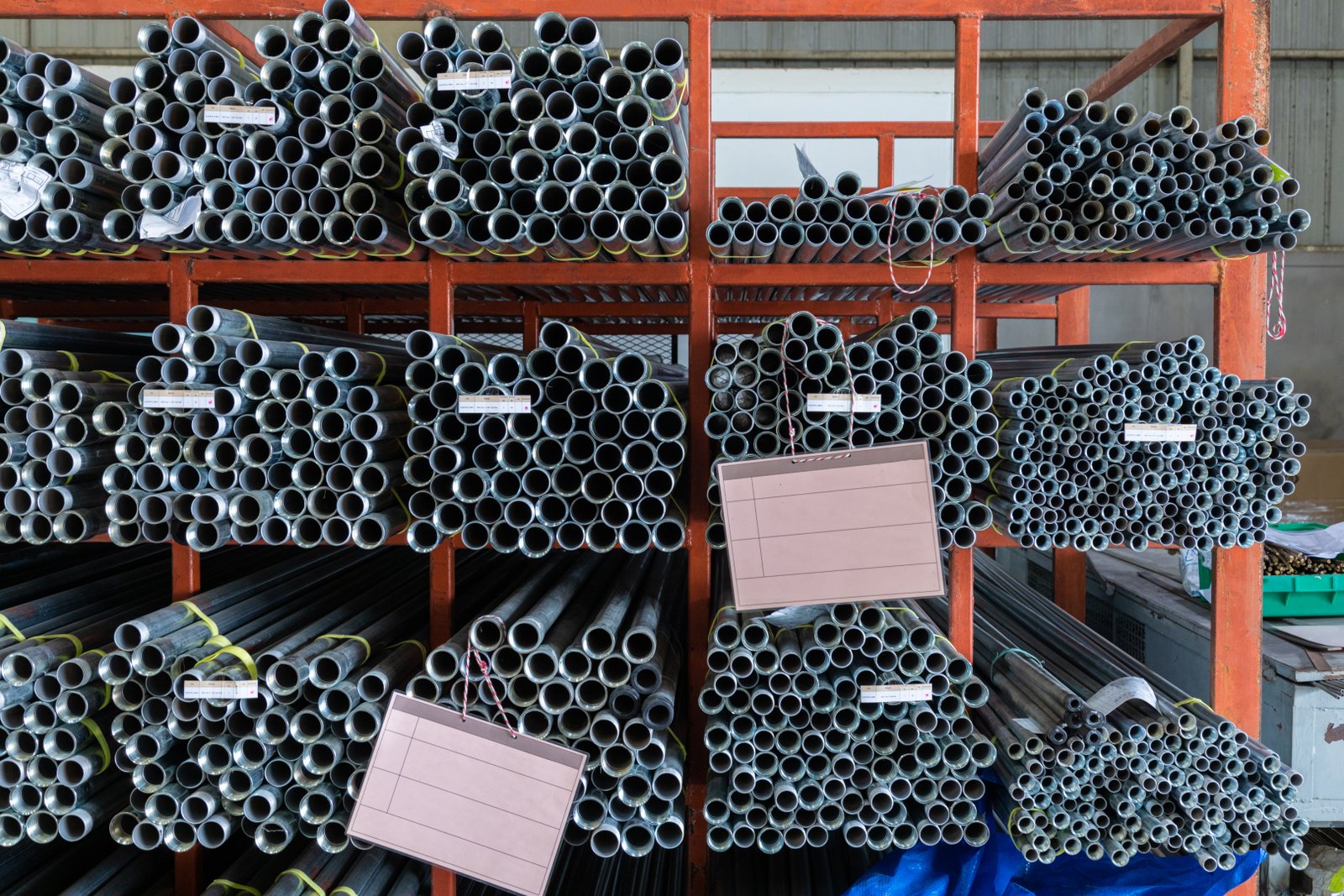 Workers loading bundled stainless steel pipes into containers for export shipment at MFY facility