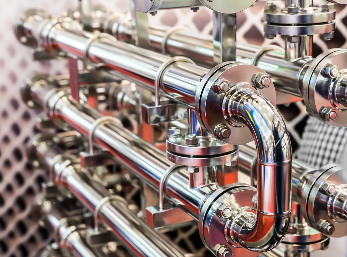 Close-up of shiny stainless steel pipes with flanges and fittings for industrial use