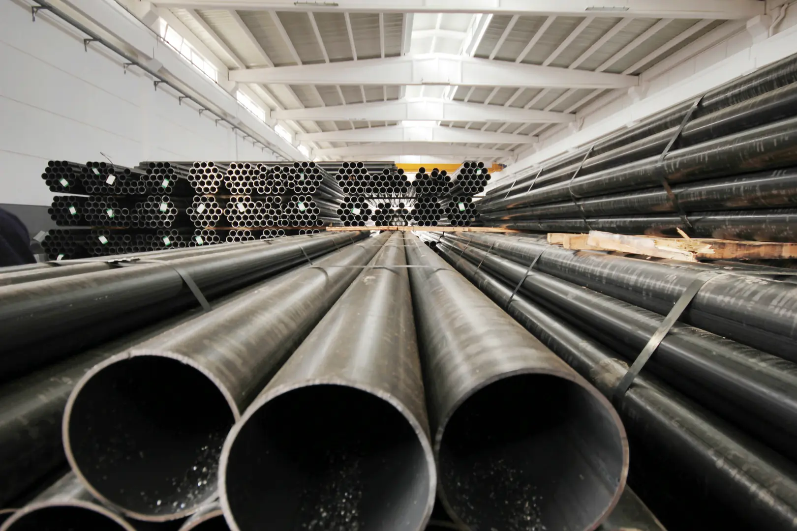 Rows of high-quality stainless steel pipes stored in an industrial warehouse, showcasing manufacturing and storage capabil...